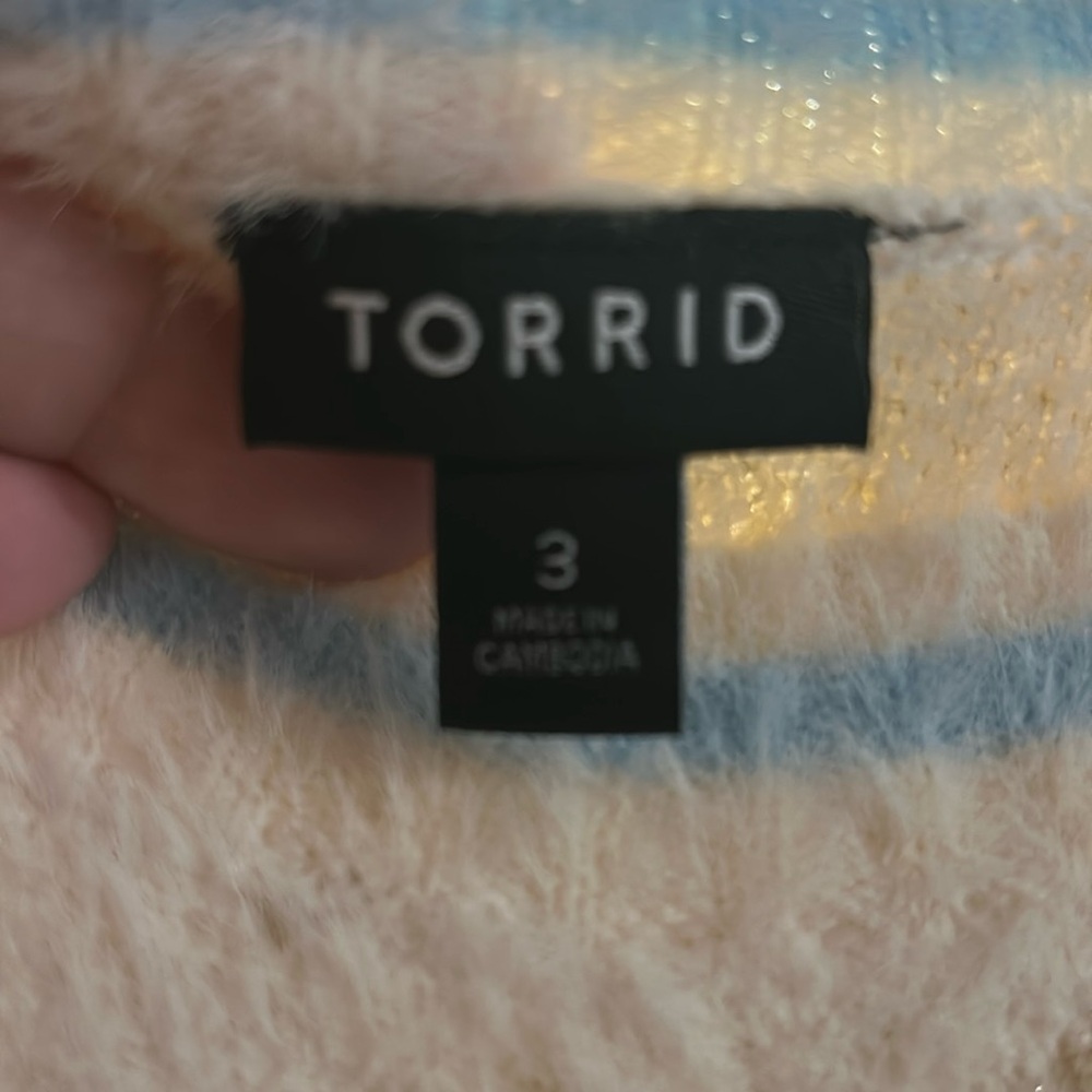 Super soft cream color cashmere sweater with light blue trim and gold accent.